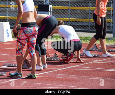 Les femmes se préparent à la ligne de départ de la piste de course Banque D'Images