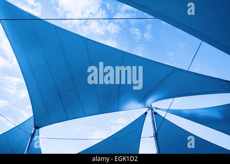 Les auvents des voiles forme sur fond de ciel nuageux. Photo dans les tons bleus Banque D'Images