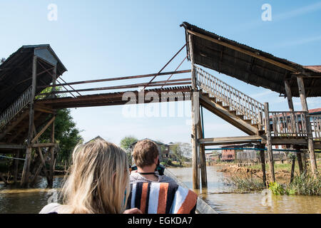 En passant sous le pont en bois.Les touristes en bateau rapide ,longboat,bateau à moteur à longue queue sur le canal navigable de Lac Inle (Birmanie, Myanmar, Banque D'Images