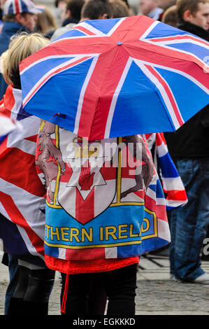 5 janvier 2013. Belfast, en Irlande du Nord - une femme porte un drapeau de l'Irlande du Nord, et porte un parapluie union jack comme plus de 1 000 syndicalistes ont participé à une solution pacifique, mais tendue, manifestation à Belfast. Les routes ont été fermées pendant environ 60 minutes alors que les manifestants agitaient des drapeaux de l'Union et applaudi. Les manifestations suivez la décision au début de décembre que le drapeau de l'Union européenne ne doit être survolé Belfast City Hall sur 15 jours de «désigné. Banque D'Images