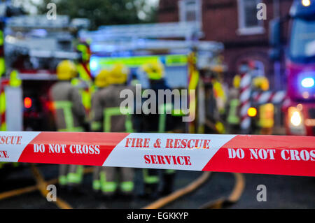 Fire Brigade place ruban cordon autour d'une scène d'incendie criminel soupçonné d'assurer la sécurité des gens et préserver les preuves. Banque D'Images