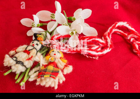 Martenisa - coutume bulgare traditionnelle - Fond rouge avec les perce-neige Banque D'Images