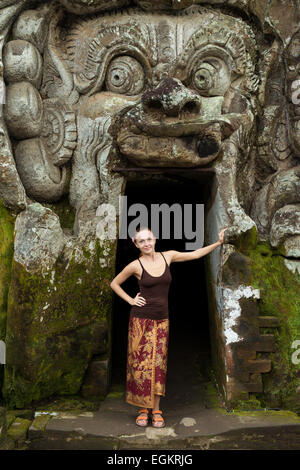 Jeune femme debout dans la bouche du démon à Goa Gajah - Ubud, Bali, Indonésie Banque D'Images