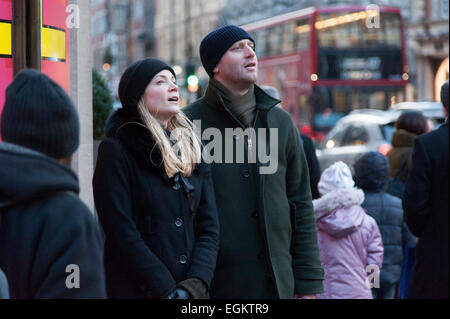 L'homme et la femme se tient en dehors de Harvey Nichols à Knightsbridge, Londres et à la recherche dans la rue. Banque D'Images