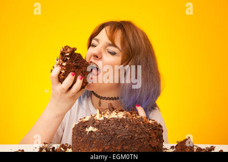 Jeune femme sur le point de manger une grande tranche de gâteau au chocolat. Banque D'Images