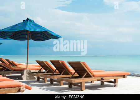 De nombreuses chaises longues avec parasols à la plage sur l'océan Banque D'Images