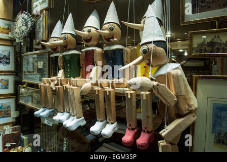 Une série de marionnettes pinocchio en bois assis dans une rangée Banque D'Images