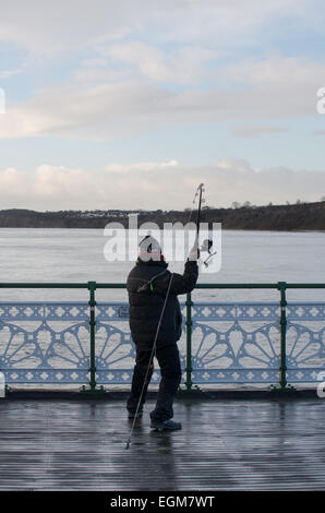 Une image d'un pêcheur au large de la mer la pêche à la ligne primée Penarth pier Banque D'Images