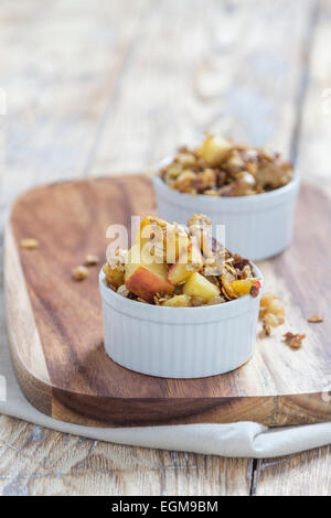 Deux bols de crumble aux pommes sur une planche en bois sur une table rustique Banque D'Images