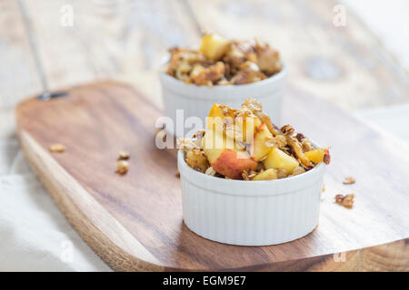 Deux bols de crumble aux pommes sur une planche en bois sur une table rustique Banque D'Images