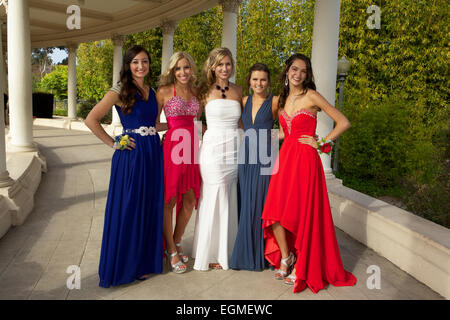 Cinq belles jeunes filles en robe de soirée en souriant et posant pour une photo à l'extérieur Banque D'Images