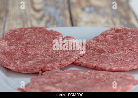 Trois des pâtés de bœuf sur une plaque sur une table en bois rustique Banque D'Images