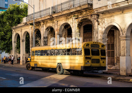 Un classique des années 50 Americana autobus scolaire garé sur le côté de la rue à La Havane, Cuba, en regard de l'architecture coloniale. Banque D'Images