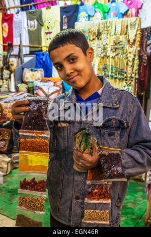 Un jeune garçon égyptien vend des épices aux touristes dans le marché ou souk à Louxor, Égypte. Banque D'Images