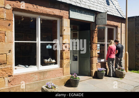 Les jeunes touristes de navigation dans la fenêtre de la galerie Loft & Atelier d'artisanat à St Margaret's Hope, South Ronaldsay, Orcades, en Écosse. Banque D'Images