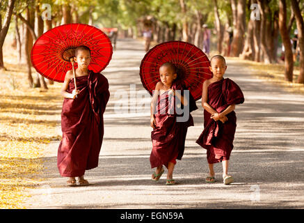 Trois jeunes moines bouddhistes marchant le long d'une route, Bagan, Myanmar ( Birmanie ), l'Asie Banque D'Images