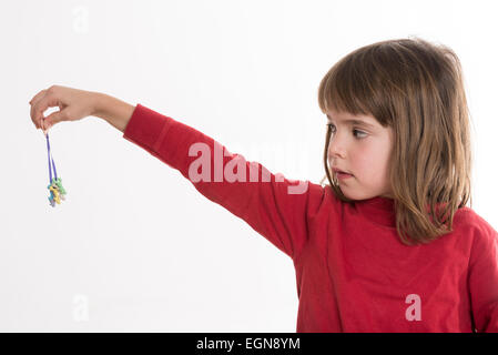 Petite fille à la recherche d'une petite touches de couleur isolé sur fond blanc Banque D'Images