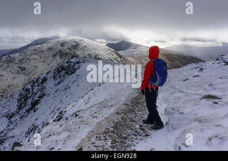 Randonneur sur Coniston le vieil homme montagne avec de la neige en hiver dans les montagnes du Parc National de Lake District Cumbria England UK Grande-Bretagne Banque D'Images