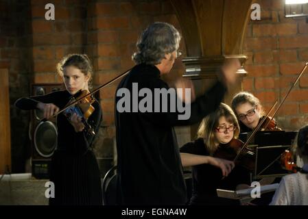 Riga Lettonie. Chef d'orchestre, violoniste et chef d'orchestre de jeunes membres au cours de la musique classique à l'intérieur de Saint Peters Church considérant Banque D'Images