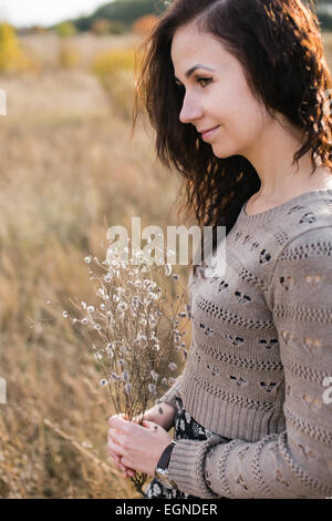 Portrait d'une jeune femme tenant un bon bouquet composé de fleurs sèches Banque D'Images