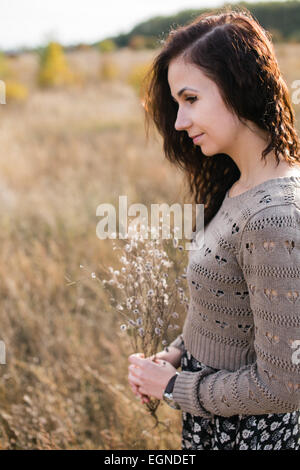 Portrait d'une jeune femme tenant un bon bouquet composé de fleurs sèches Banque D'Images