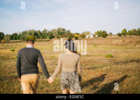 Image d'un jeune couple qui marche main dans la main au coucher du soleil d'automne Banque D'Images