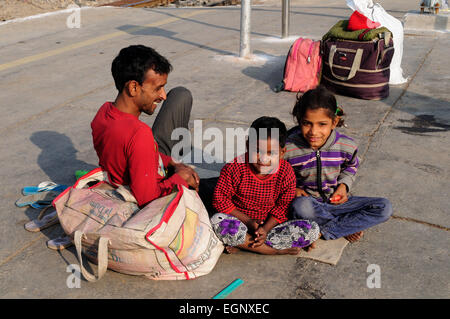 Un père et ses deux jeunes enfants de l'emplacement sur la plate-forme de la gare de New Delhi en arrivant de la campagne l'Inde Banque D'Images