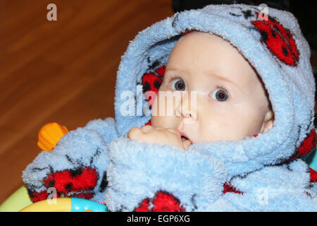 Petit bébé bleu en robe de chambre avec vue étonné Banque D'Images