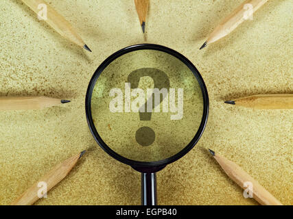 Point d'interrogation sous une loupe sur vintage background Banque D'Images