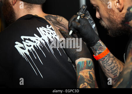 Manchester, UK 28 Février, 2015. Un nombre record d'amoureux d'encre avec bras tatoués ont assisté à la 14e conférence annuelle de Manchester International Tattoo Show. Des milliers d'amateurs de tatouage affluent dans la ville ce week-end pour obtenir encré par certains des meilleurs artistes du corps. Manchester International Tattoo Show retourne à Manchester Central le samedi et dimanche avec une gamme de plus de 250 tatoueurs et perceurs de corps à travers le Royaume-Uni, l'Europe et les USA. Banque D'Images