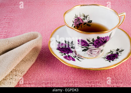 Une tasse de thé dans une tasse de porcelaine fine fabriqué en Angleterre sur un chiffon et serviette de table tissé à la Banque D'Images