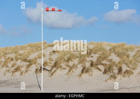 Une manche à air souffle dans de forts vents de sable avec des dunes derrière Banque D'Images