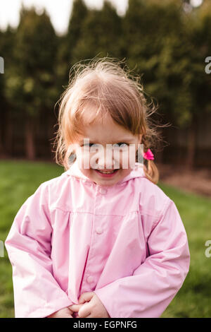 Portrait d'une jeune fille dans un parc avec un manteau de pluie sur cette photo lifetsyle. a été tourné avec lumière naturelle. Banque D'Images