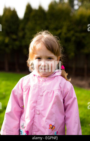 Portrait d'une jeune fille dans un parc avec un manteau de pluie sur cette photo lifetsyle. a été tourné avec lumière naturelle. Banque D'Images