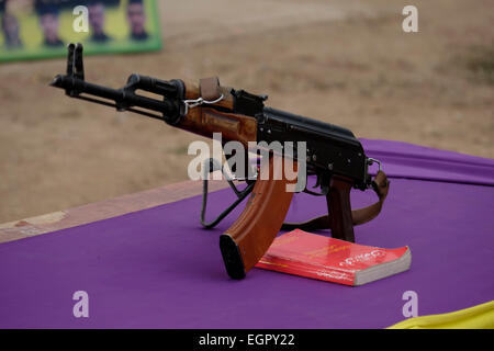 Une Kalachnikov AK-47 placé sur une table avec la pensée politique du leader kurde Abdullah Ocalan et l'un des membres fondateurs des militants du Parti des Travailleurs du Kurdistan PKK durant la cérémonie d'assermentation de combattants kurdes GPJ dans un camp de recrutement à Al Hasakah ou district Hassakeh en Syrie du nord Banque D'Images