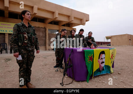 Participation des combattants kurdes des unités de protection des femmes YPJ dans un processus de cisaillement sur un drapeau portant le chiffre De l'ancien chef militant du PKK Abdullah Ocalan dans une formation Camp dans le district d'Al Hasakah ou de Hassakeh, dans le nord de la Syrie Banque D'Images