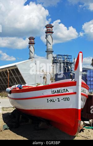 Rouge et blanc en bois traditionnel bateau de pêche avec la raffinerie pétrochimique à l'arrière, Puente Mayorga, Province de Cadix, Espagne Banque D'Images