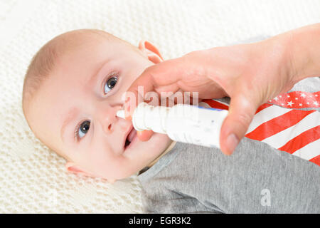 Femme à l'aide de spray nasal pour bébé Banque D'Images