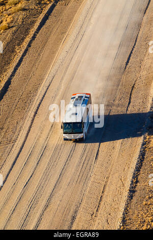 Une antenne de droit d'un bus roulant sur une route de terre en Namibie. Banque D'Images