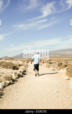 Homme marchant sur le sentier à partir de la Montana Roja, El Medano, Tenerife, Canaries, Espagne sur une journée ensoleillée Banque D'Images