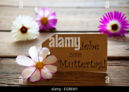 Étiquette marron avec texte allemand Alles Liebe Zum Muttertag avec Mauve et blanc Cosmea fleurs sur fond de bois Vintage Retro Banque D'Images