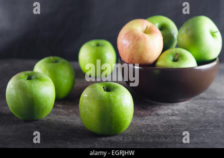 Bol de pommes vertes et d'apple sur planche de bois Banque D'Images