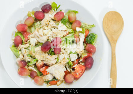 Mélanger avec la salade de poulet et les raisins sur le plat blanc Banque D'Images