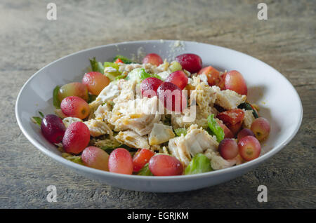 Mélanger avec la salade de poulet et les raisins sur le plat blanc Banque D'Images