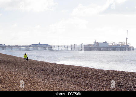 Janvier 2015 : Tôt le matin en hiver sur la plage de Brighton, un ouvrier solitaire est la collecte des déchets. Banque D'Images