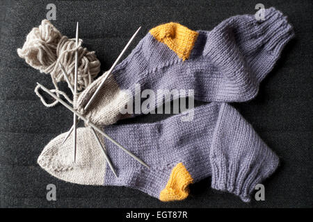 Chaussettes tricotées à la main pourpres, grises et jaunes avec de grosses mailles de laine, aiguilles à tricoter dans le Carmarthenshire Wales UK KATHY DEWITT Banque D'Images