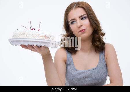 Portrait of a smiling woman looking at le gâteau sur fond gris Banque D'Images