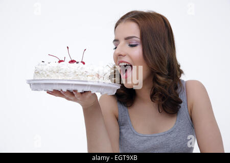 Portrait d'une jeune femme mordant sur fond gris gâteau Banque D'Images