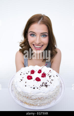 Portrait of a smiling woman with cake sur fond gris Banque D'Images