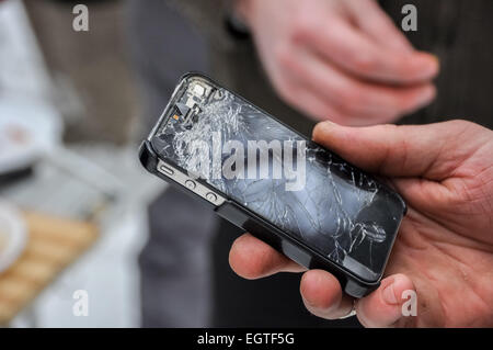 Téléphone avec un écran cassé dans une main Banque D'Images